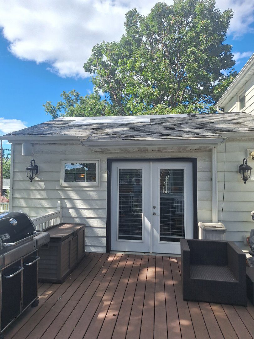 Low-slope roof edge and siding inspected after storm exposure in Minneapolis, Minnesota